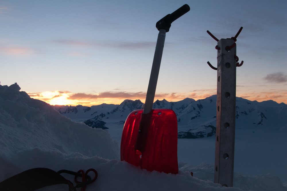 Eine Schneeschaufel im Schnee bei Sonnenuntergang