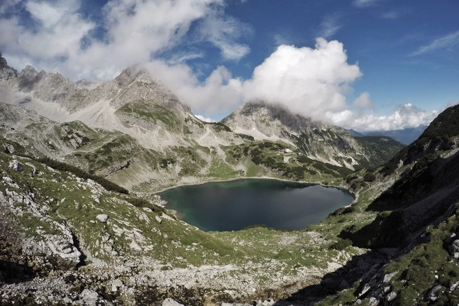 Einzigartig leuchtet das blaue, kristallklare Wasser des Drachensees, in dem sich die schroffen Felsgebirgsz&uuml;ge der Mieminger Kette widerspiegeln. Der Bergsee liegt direkt unterhalb der Coburger H&uuml;tte (1.917 Meter). Von hier er&ouml;ffnen sich mehrere anspruchsvolle Gipfelm&ouml;glichkeiten wie die Tajak&ouml;pfe oder die Ehrwalder Sonnenspitze. | Foto: Christian Greither Photography