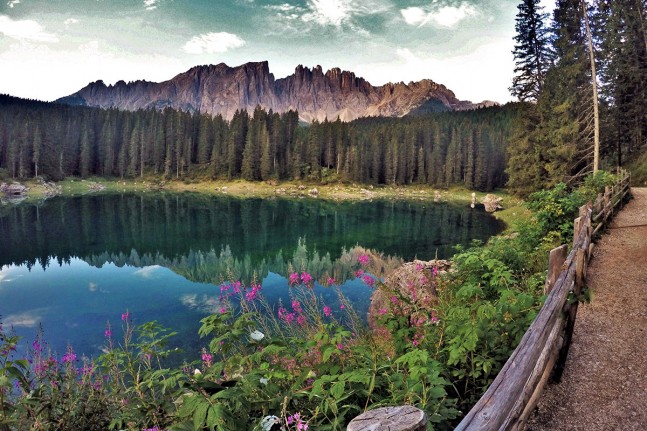 Im Karersee (1.519 Meter) unterhalb des Karerpasses in den westlichen Dolomiten spiegeln sich der Rosengarten und der Latemar. Der Bergsee wird wegen seiner beeindruckende Farben im Ladinischen auch "Lec de Ergobando" (Regenbogensee) genannt und ist ein gesch&uuml;tztes Naturdenkmal. | Foto: Christian Greither Photography