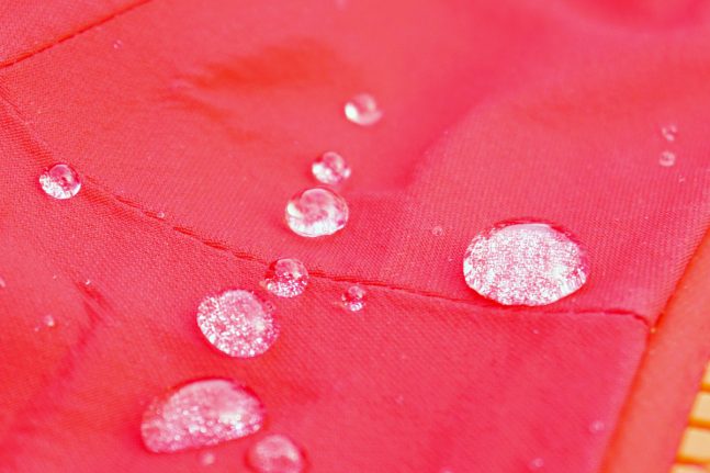 An einem rosa Kleidungsst&uuml;ck abperlende Wassertropfen.