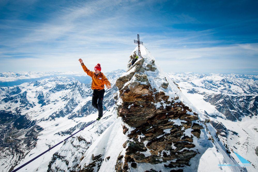 Slackliner auf Highline vor schweizer Winterpanorama