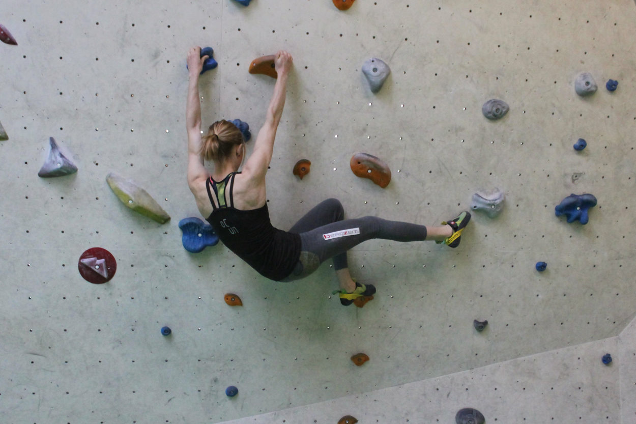 Sophie Arnold in der Boulderhalle bei der Übung "Tritte angeln" zur Stärkung der seitlichen Bauchmuskulatur.