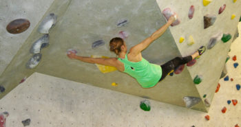 Boulderin trainiert an einer Boulderwand.