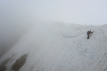 Bergsteiger quert einen steilen, vereisten Abhang zurück zum Whymper Couloir bei der Besteigung der Aiguille Verte.