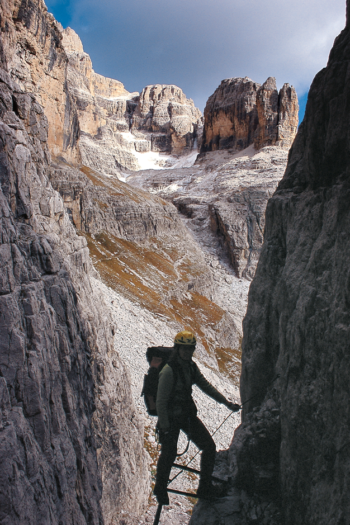 Klettersteiggeher in einem Kamin am Ende des Sentiero SOSAT Klettersteig in der Brenta.