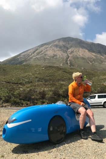Frau sitzt auf Velomobil mit Fahhradbekleidung von Vaude