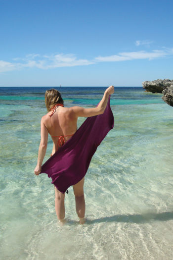 Frau mit Reisehandtuch im Meer