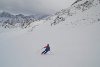 Eine Skifahrerin mit dem Blick auf ein Bergpanorama.