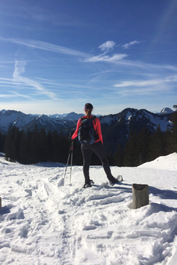 Eine Schneeschuhwanderin genießt den Ausblick.