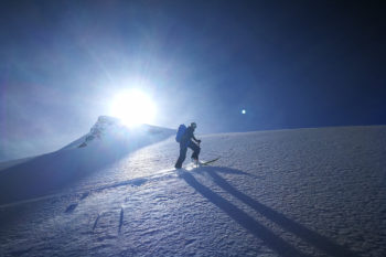 Ein Tourenskigeher im Aufstieg bei strahlendem Sonnenschein.