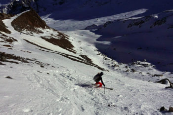 Eine Person beim Skifahren in felsigem Gelände.