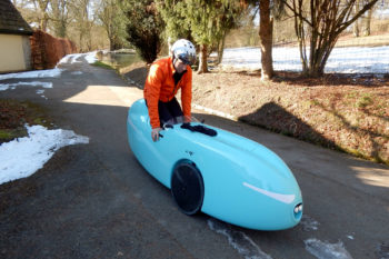 Ein Mann steigt in sein Velomobil.
