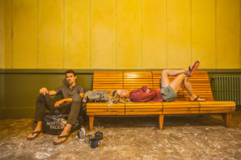 Mann und Frau warten in der Wartehalle eines Bahnhofs