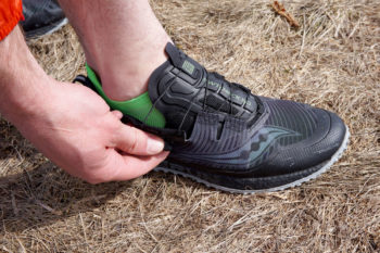Mann &ouml;ffnet Trailrunningschuh mit Boa-System