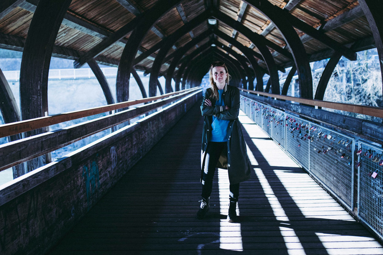 Frau auf überdachter Holzbrücke