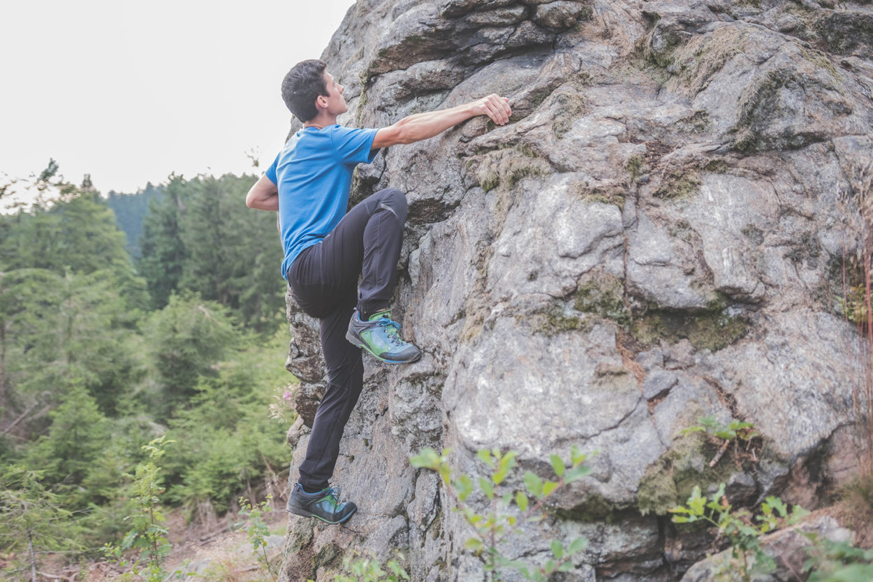 Ein Mann beim Bouldern am Fels.