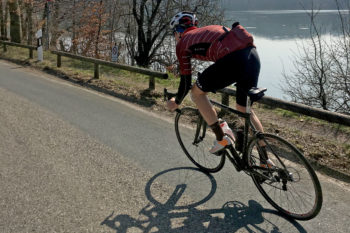 Ein Rennradfahrer auf einer Straße von hinten.