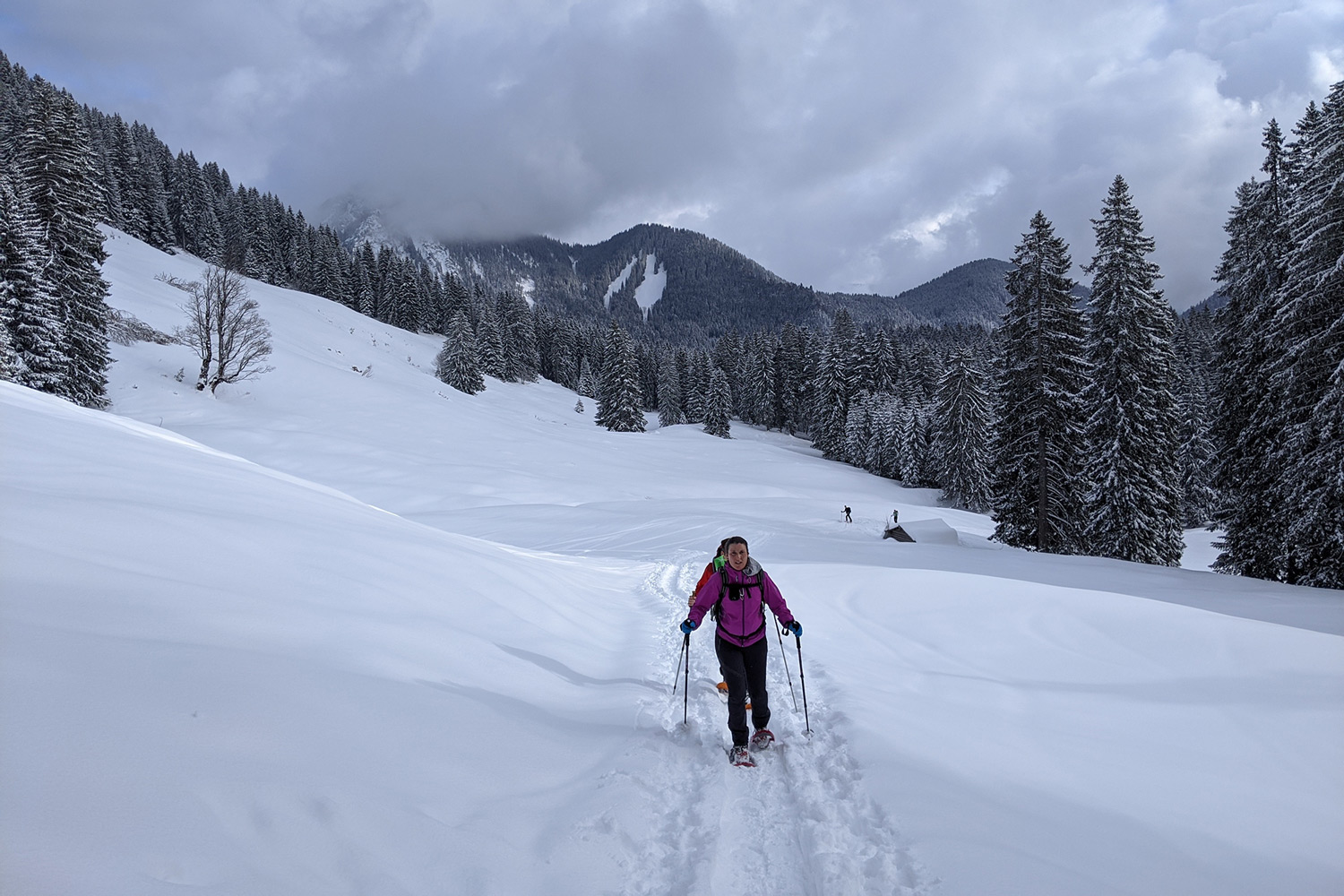 Schneeschuhgeher in einer Spur in weiß verschneiter Winter-Berglandschaft.