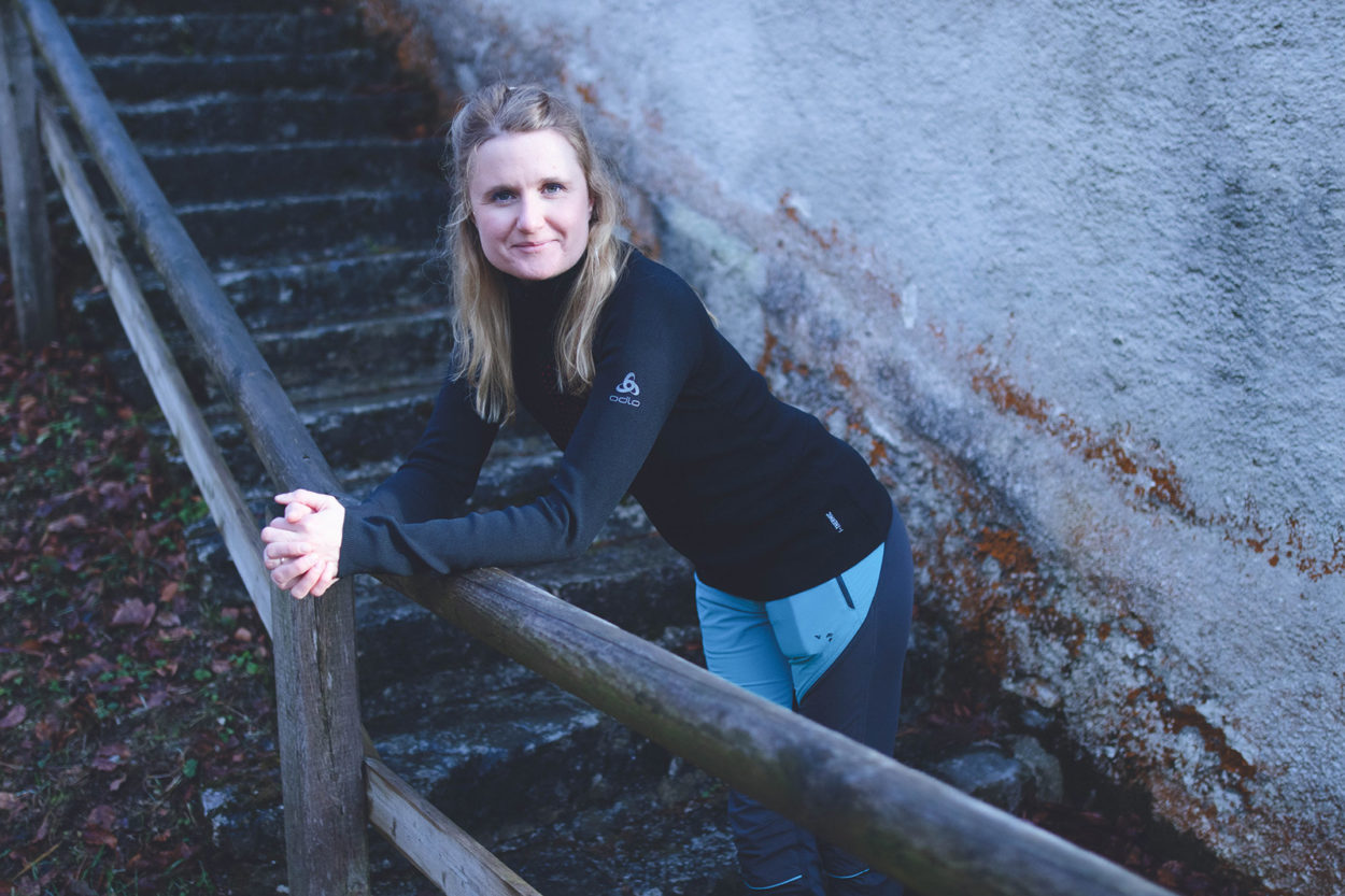 Frau lehnt bei Test des Odlo I-Thermic Longsleeve an Holzbrüstung