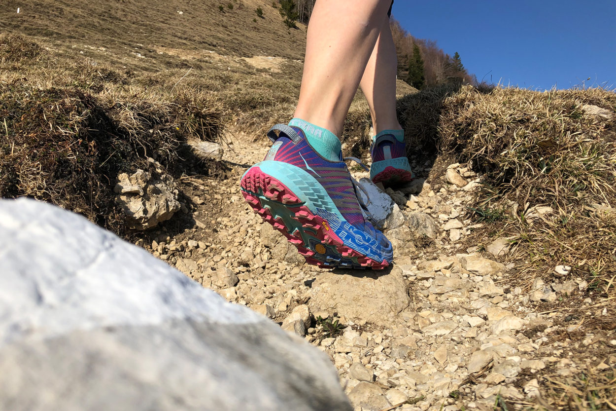 Hoka One One Speedgoat 4 mit Vibram Sohle auf felsigem Trail im Aufstieg