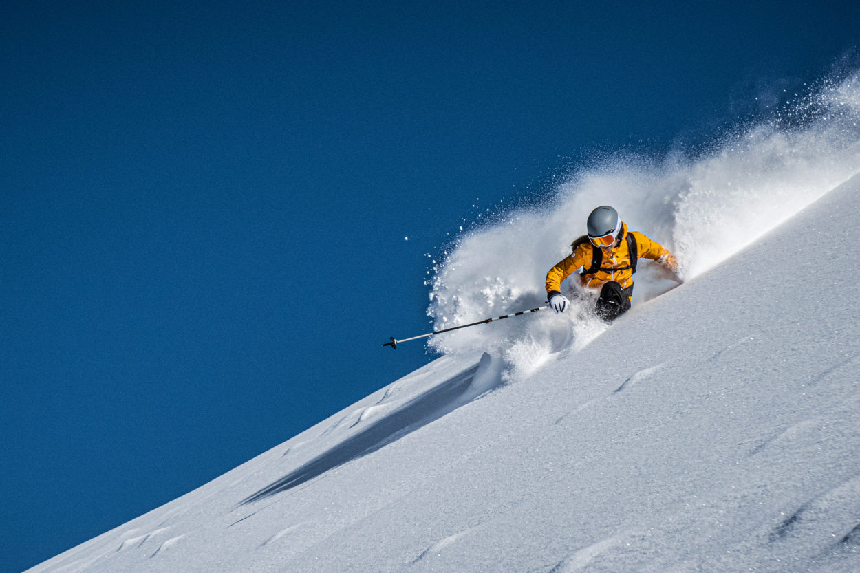 Skifahrerin im Tiefschnee mit Schneestaub